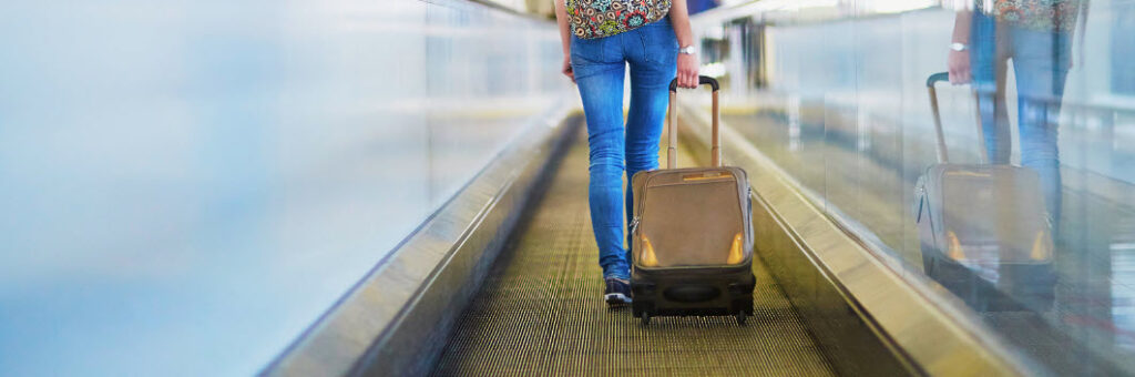 best softside carry-on luggage - woman on travelator