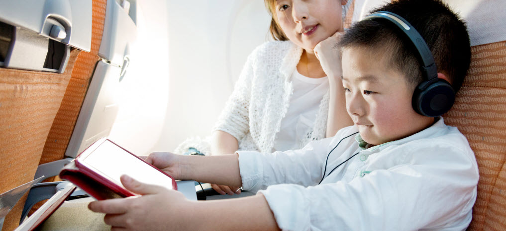 must haves for flying - boy with ipad and headphones