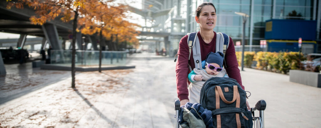 tips for flying with a baby - baby in ergo at airport