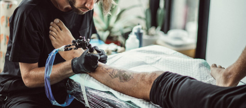 Getting a Tattoo in Bali - tattooist tattooing leg