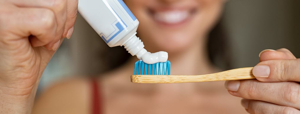 toothbrushes for travel - girl holding wooden toothbrush